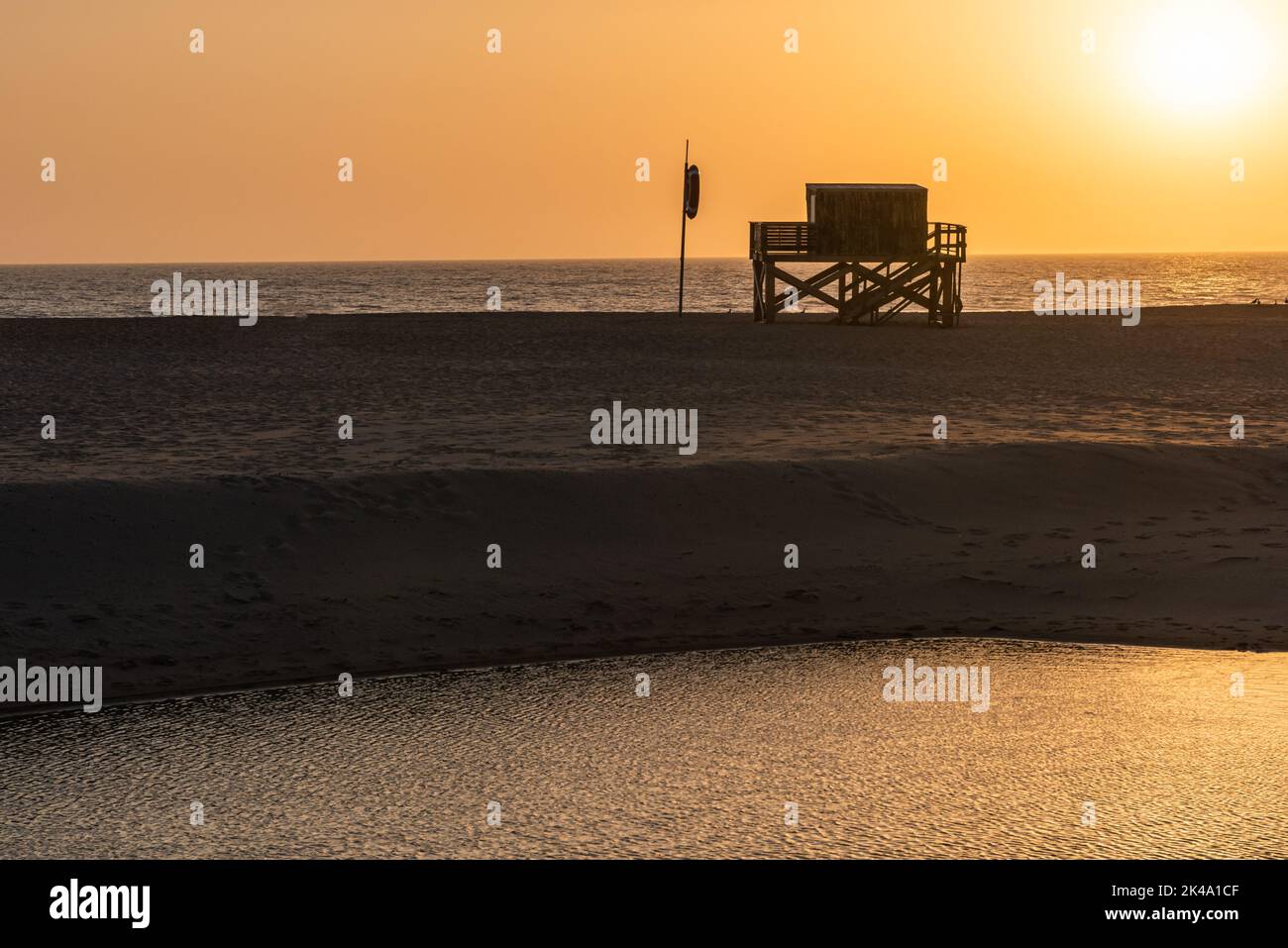 Un tramonto d'oro scenico alla spiaggia di Areia Branca a Lourinha, Portogallo Foto Stock