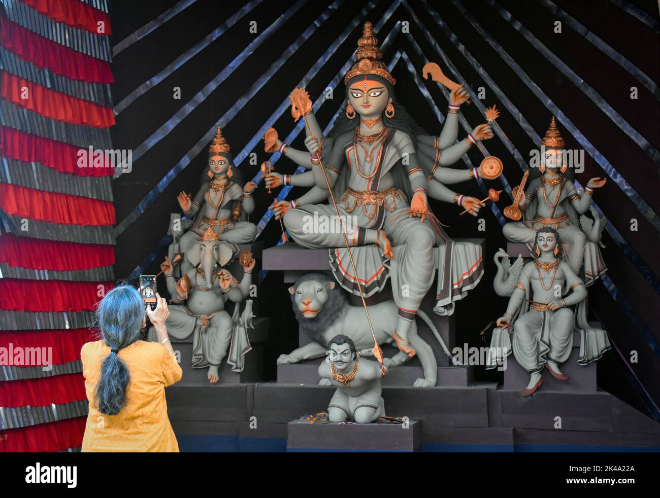 1 ottobre 2022, Kolkata, Bengala Occidentale, India: Una donna sta scattando foto dell'idolo Durga sul suo cellulare all'interno di un pandal o di una piattaforma temporanea in occasione del festival Durga Puja di Kolkata. (Credit Image: © Sudipta Das/Pacific Press via ZUMA Press Wire) Foto Stock