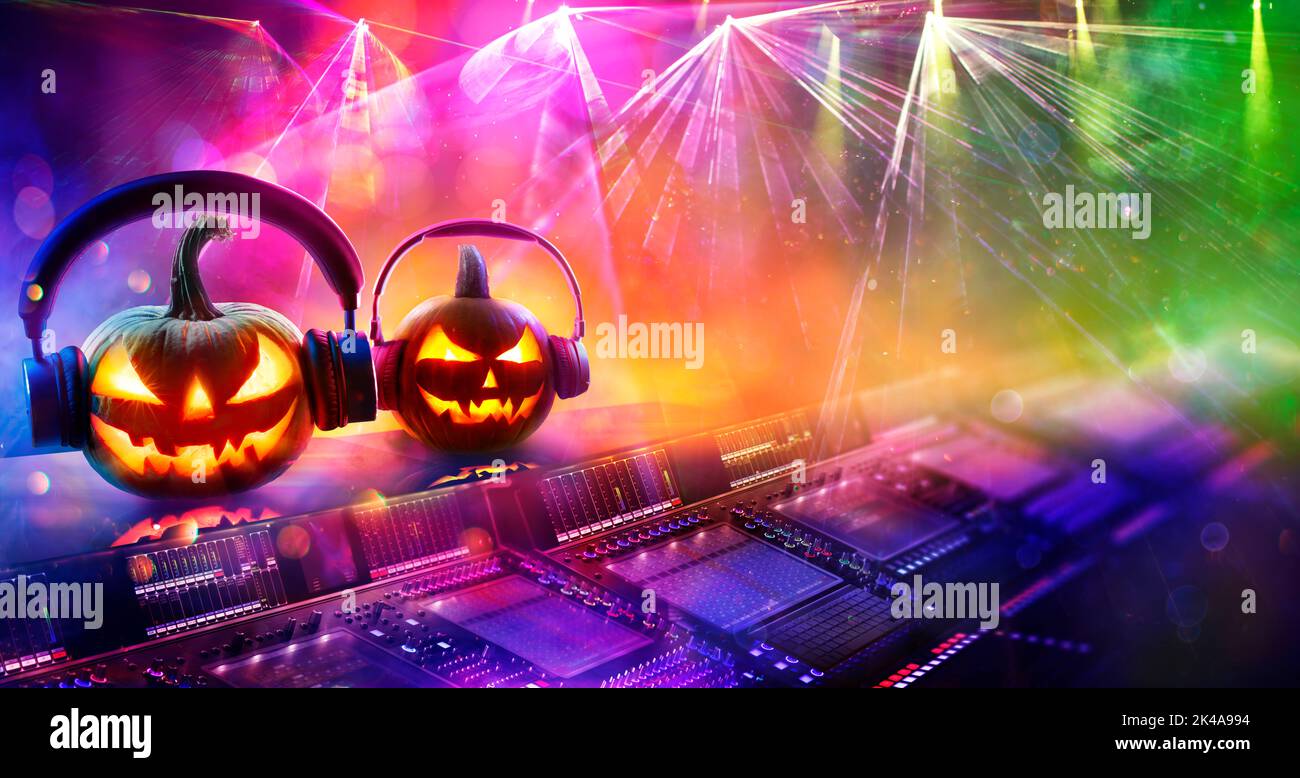 Musica discoteca di Halloween - zucche con cuffie in discoteca con Confetti e luci astratte sfocate Foto Stock