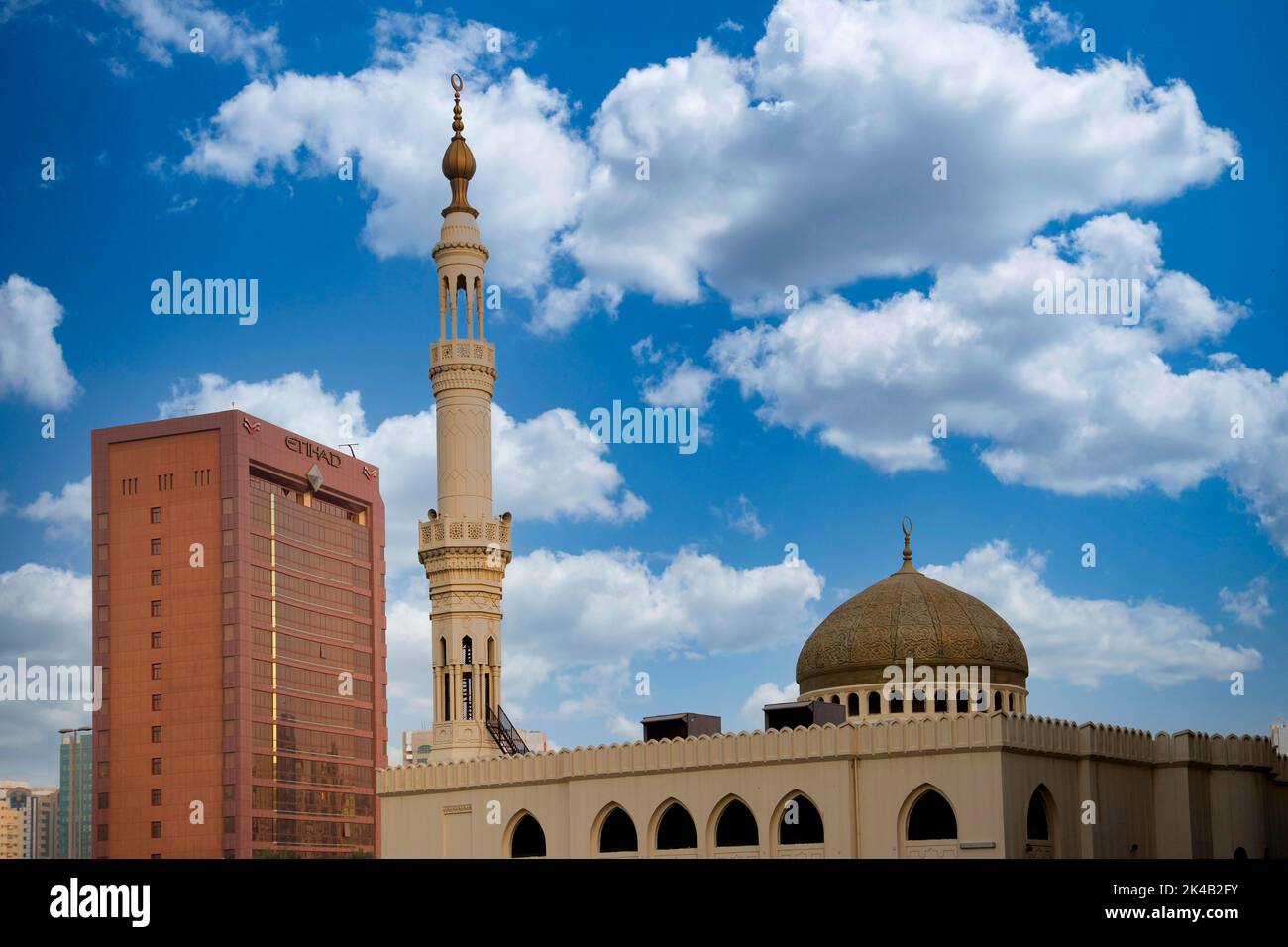 In primo piano una moschea, accanto ad essa l'edificio del quartier generale di Etihad Airways, Abu Dhabi, Emirati Arabi Uniti Foto Stock