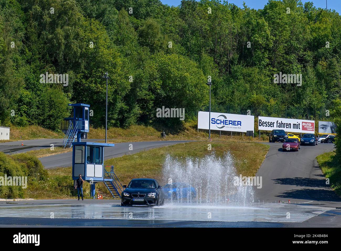 BMW M2 vettura sportiva mantiene il controllo schivare ostacoli sotto forma di fontane d'acqua su superfici scivolose, FSZ II centro di sicurezza al volante, gara Nuerburgring Foto Stock