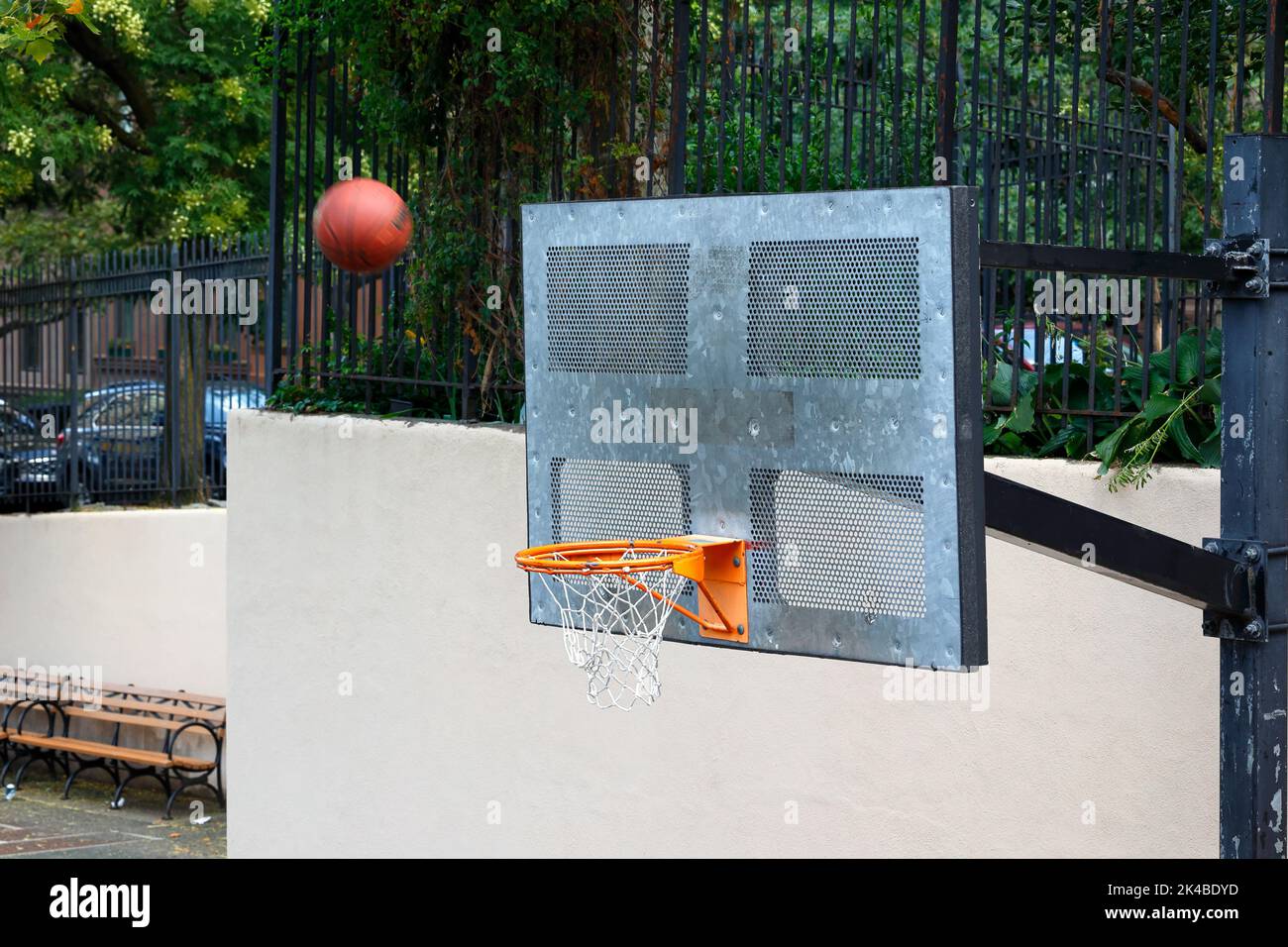 Una pallacanestro che vola attraverso l'aria verso il backboard con un risultato sconosciuto se andrà nel cerchio. Foto Stock