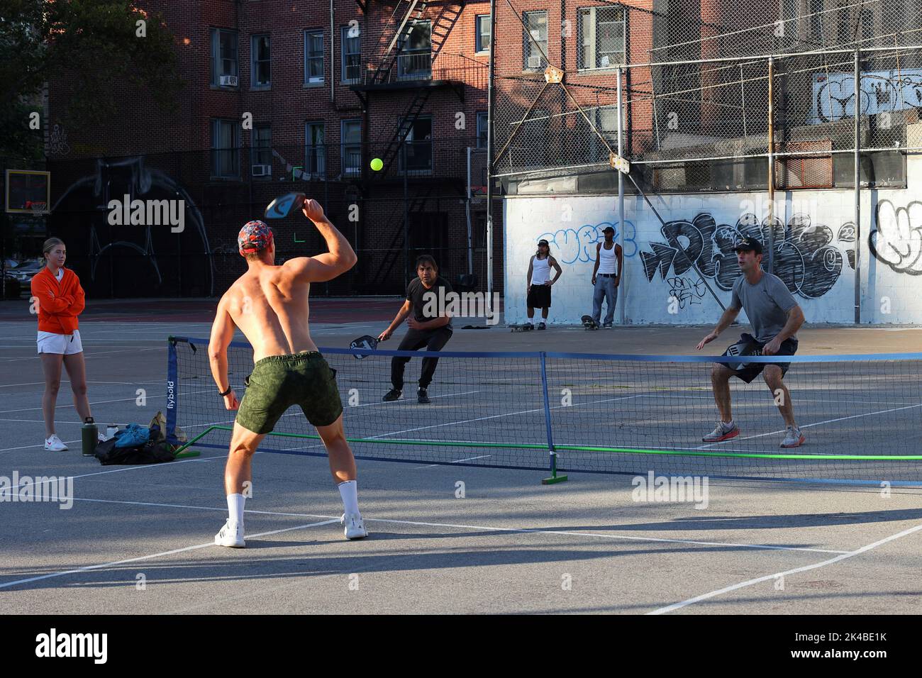 Millenial giocando a pickleball in un parco giochi urbano nel quartiere Greenwich Village di Manhattan, New York City. Foto Stock