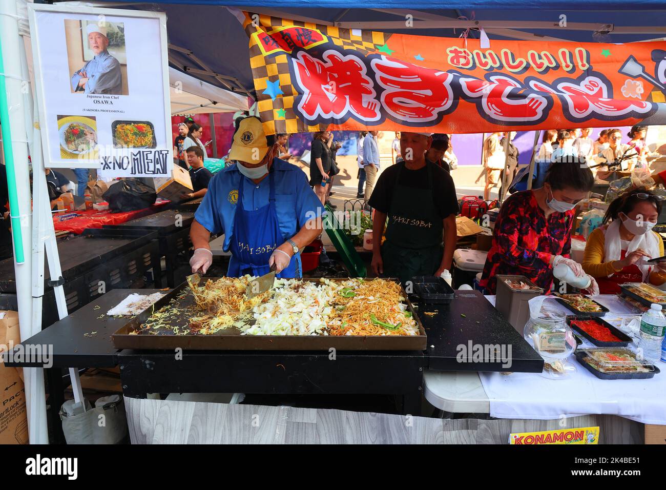 Uno chef prepara uno yakisoba senza carne 焼きそば spillare gli spaghetti saltati su una griglia piatta in una fiera di strada di Japan Fes a Manhattan, New York. Foto Stock