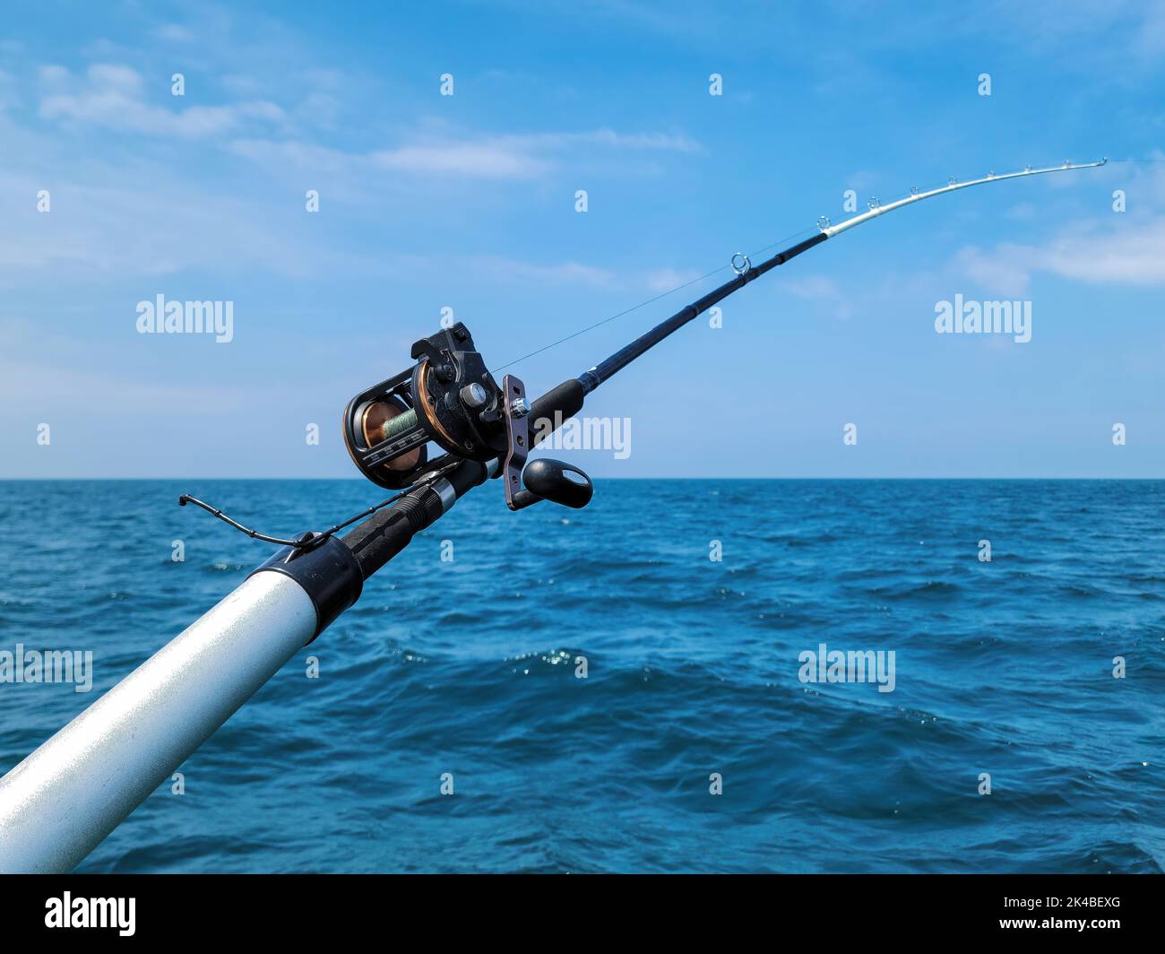 Canna da pesca e mulinello sulle acque blu del lago Michigan Foto Stock