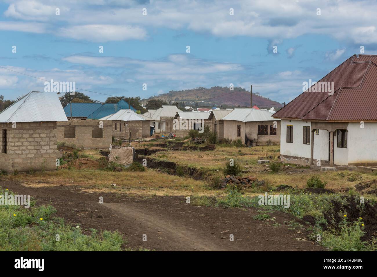 Tanzania. La Regione di Arusha. La crescita urbana. Nuovo middle-class Case in costruzione al di fuori di Arusha. Costruzione di nuovo il bypass di Arusha autostrada stimulat Foto Stock