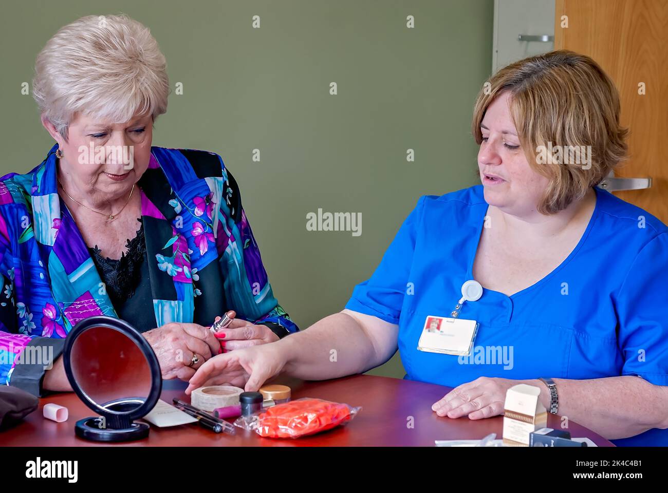 Un paziente oncologico discute di cosmetici con un infermiere registrato durante il “Look Good ... Programma "Feel Better" presso il Baptist Memorial Hospital di Columbus. Foto Stock