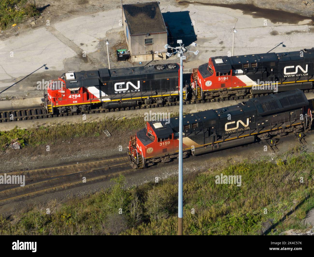 Una vista dall'alto sopra il CN Rail railyard in una giornata di sole con tre locomotive Canadian National Railway. Foto Stock