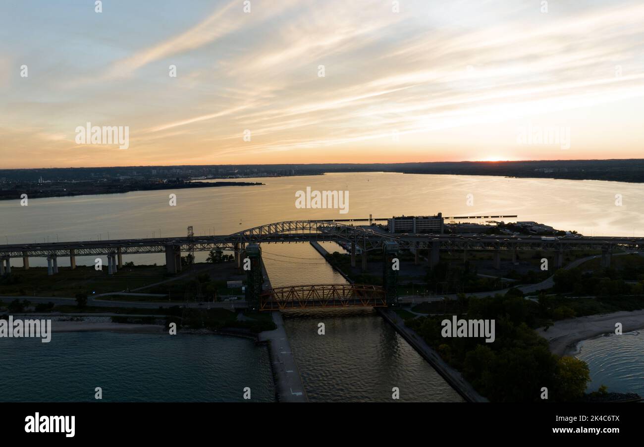 Un'alta vista aerea sul Lago Ontario che guarda al Burlington Skyway Bridge e al Porto di Hamilton durante il tramonto. Foto Stock