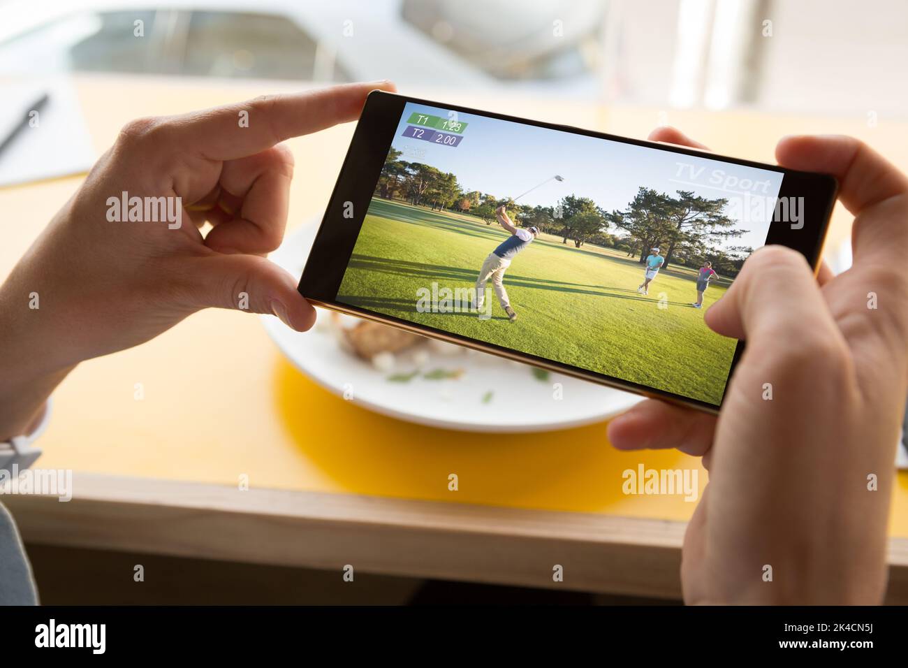 Mani di uomo caucasico al ristorante guardare partita di golf su smartphone. Sport, concorrenza, intrattenimento e tecnologia concetto digitale composito im Foto Stock