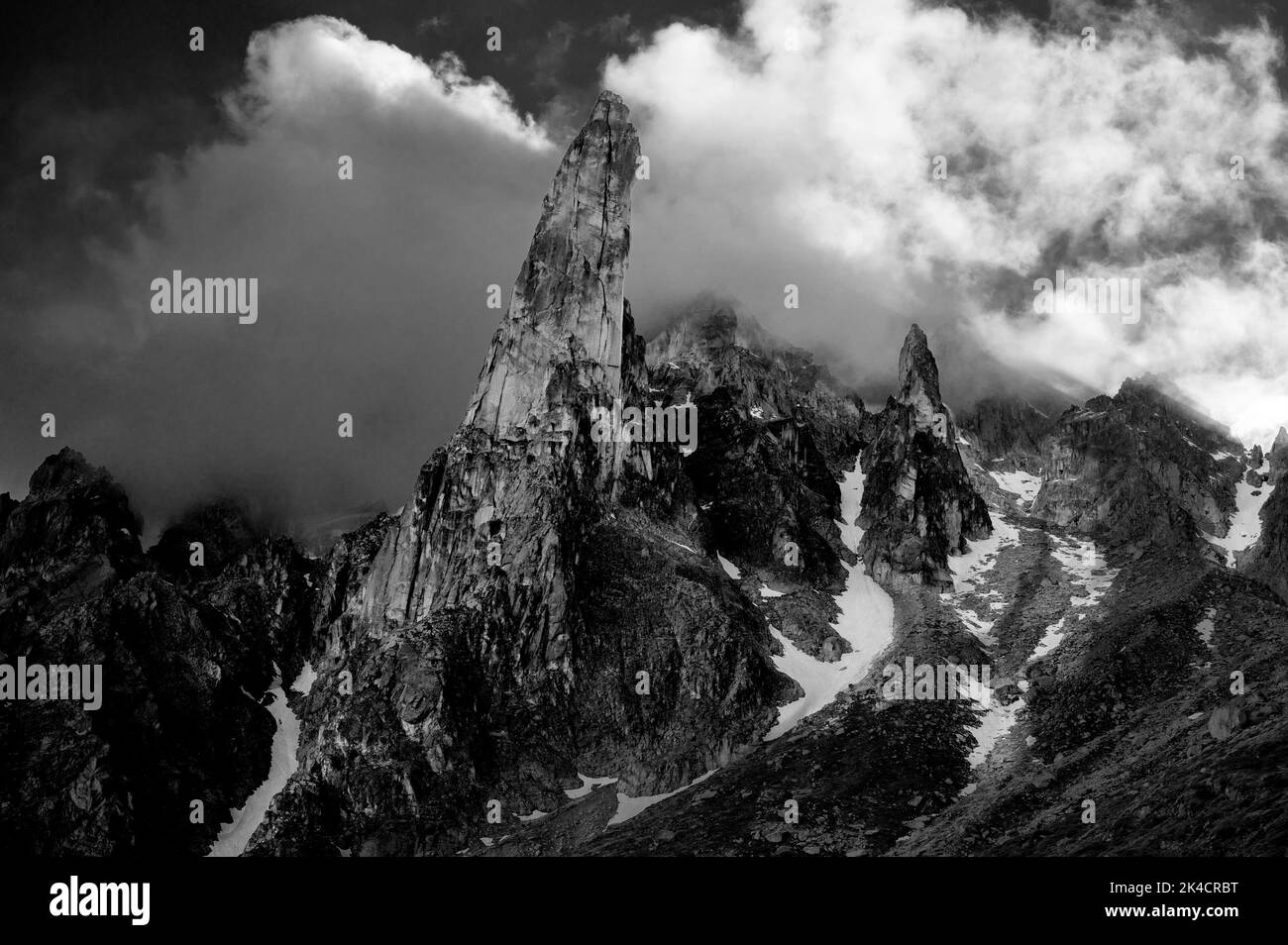 Una scala di grigi di una cima di montagna coperta di nuvole in Svizzera Foto Stock