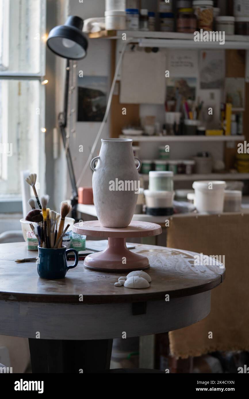 Il vaso in argilla si trova su una rastrelliera in legno che si asciuga sul tavolo e si prepara per lo schizzo per la mostra in museo Foto Stock