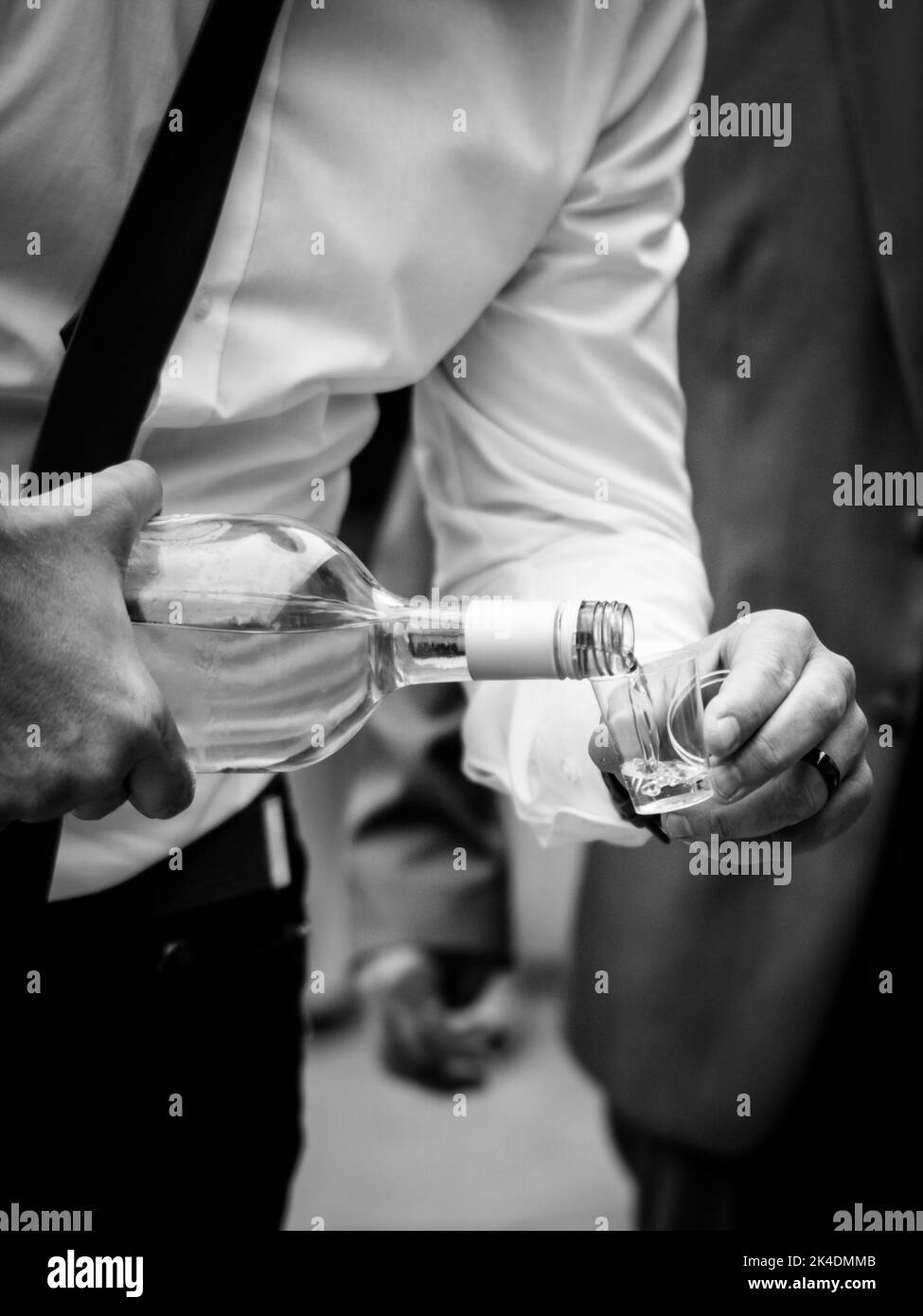 Versare la palinka al bicchiere per celebrare un matrimonio Foto Stock