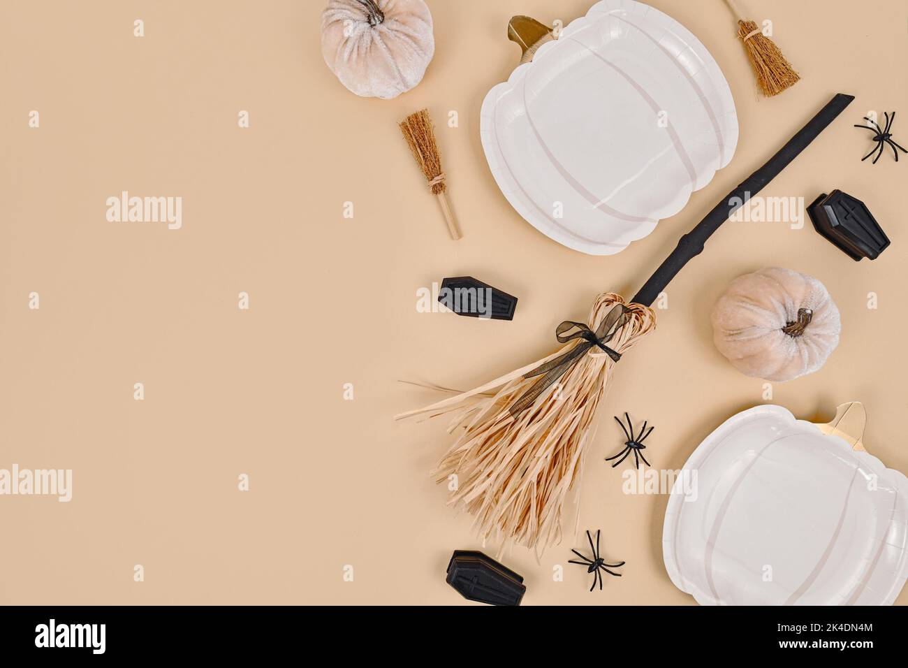 Piatto di Halloween con piatti a forma di zucca, scopa, ragni e bare su sfondo beige con spazio copia Foto Stock