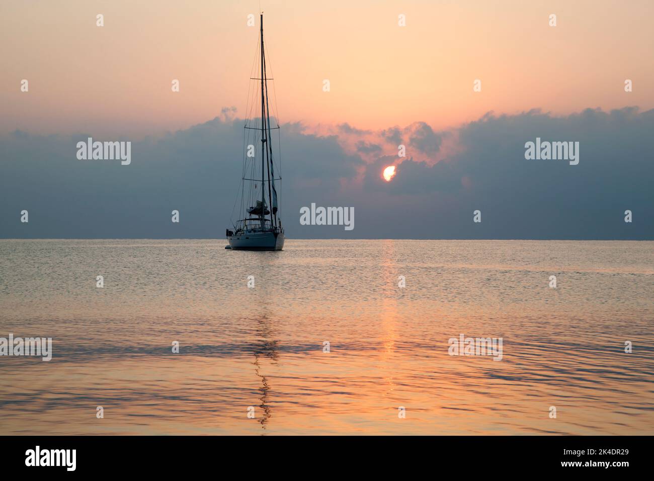 La vista di uno yacht drifting durante l'alba nuvolosa nella città di Kemer resort (Turchia). Foto Stock