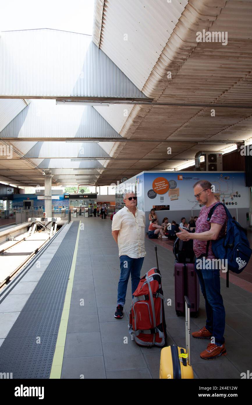 Turisti in attesa sulla piattaforma ferroviaria all'aeroporto di Barcellona, Spagna Foto Stock