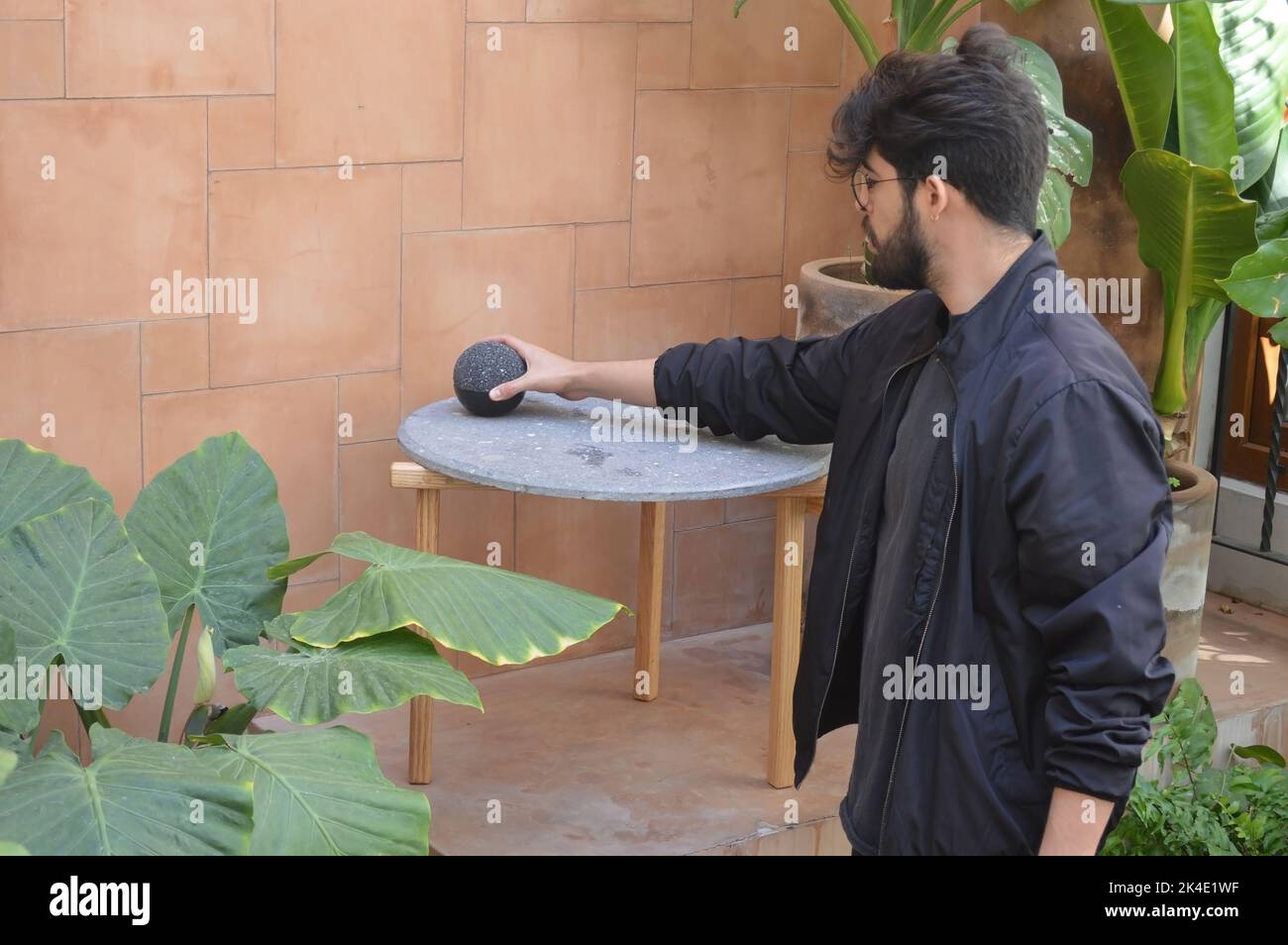 terrazza all'aperto con tavoli da caffè all'aperto, piano in pietra e base in legno massiccio o legno duro Foto Stock