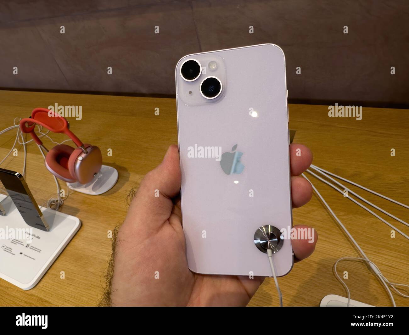 Parigi, Francia - 16 settembre 2022: POV mano maschio tenere nuovo color viola Apple computer iPhone 14 durante il giorno di lancio con la nuova fotocamera doppia potente auto rilevamento urti e satellite SOS Foto Stock