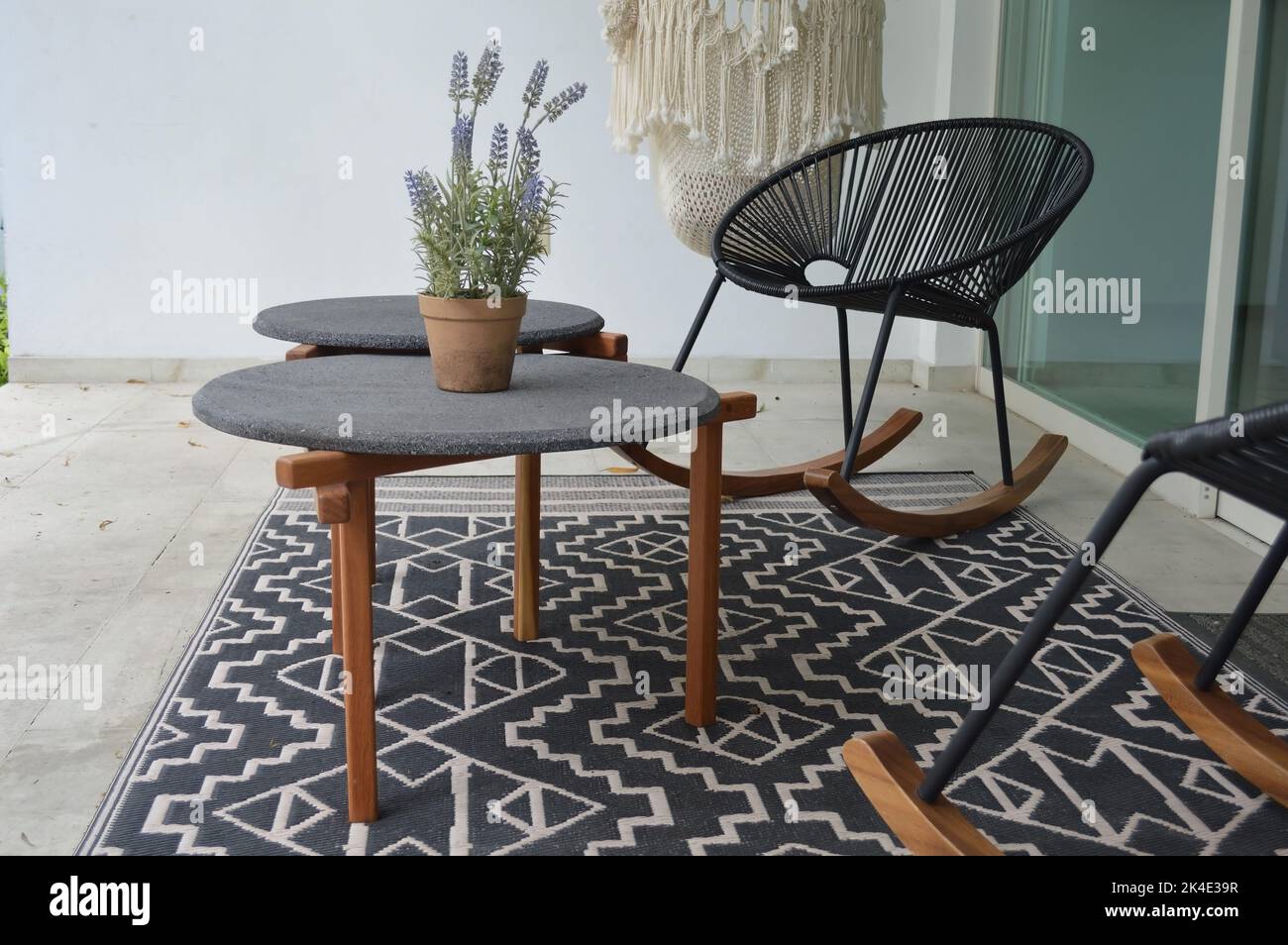 terrazza all'aperto con tavoli da caffè all'aperto, piano in pietra e base in legno massiccio o legno duro Foto Stock