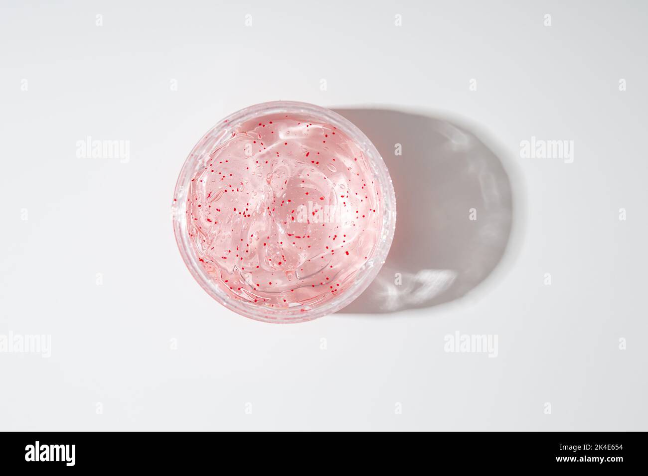 Skin care Concept gel idratante con particelle esfolianti in vaso vista dall'alto su superficie ligta Foto Stock