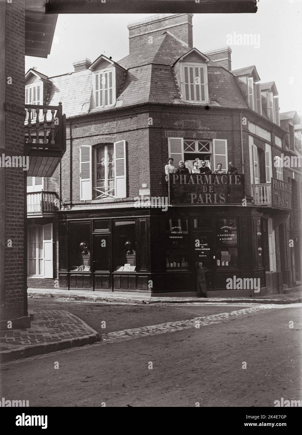 Famiglia sul balcone della loro farmacia - Normandia, Francia - nei primi anni '1900s Foto Stock