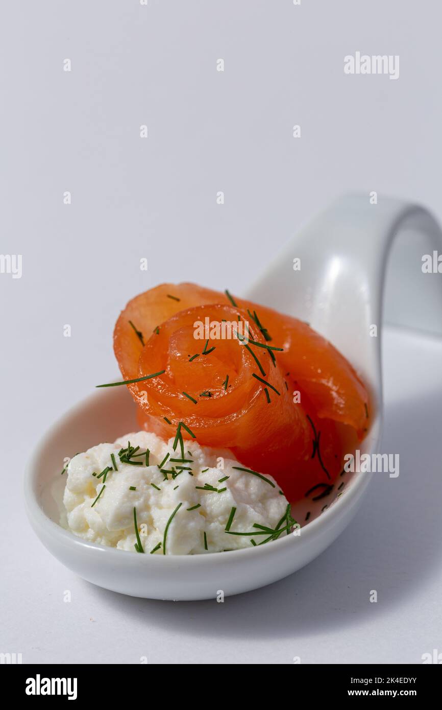 Stuzzichini su un elegante cucchiaio, salmone con formaggio cremoso in un cucchiaio di porcellana Foto Stock