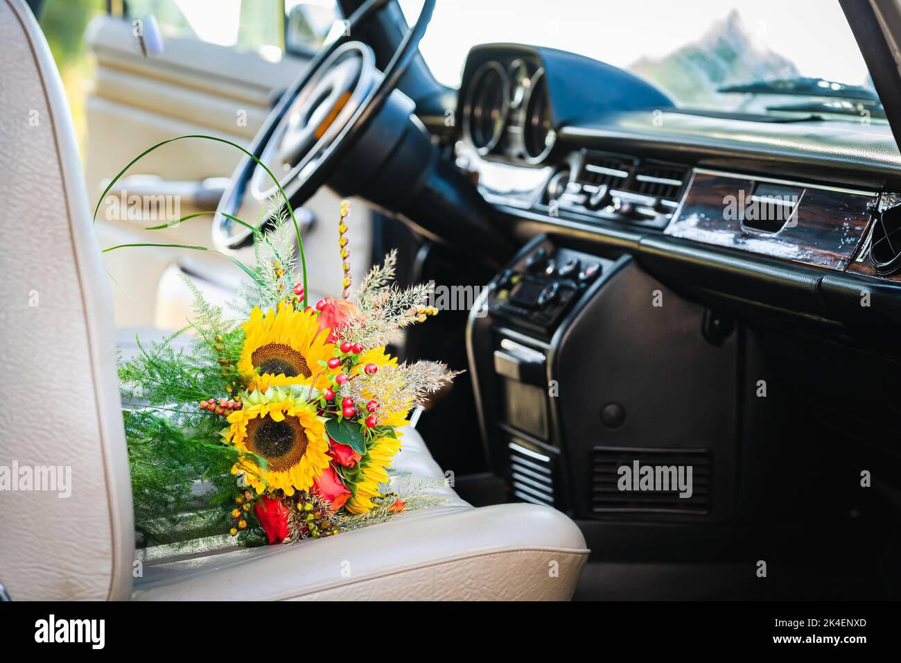 Auto da sposa vintage con bel bouquet di rose e girasoli Foto Stock