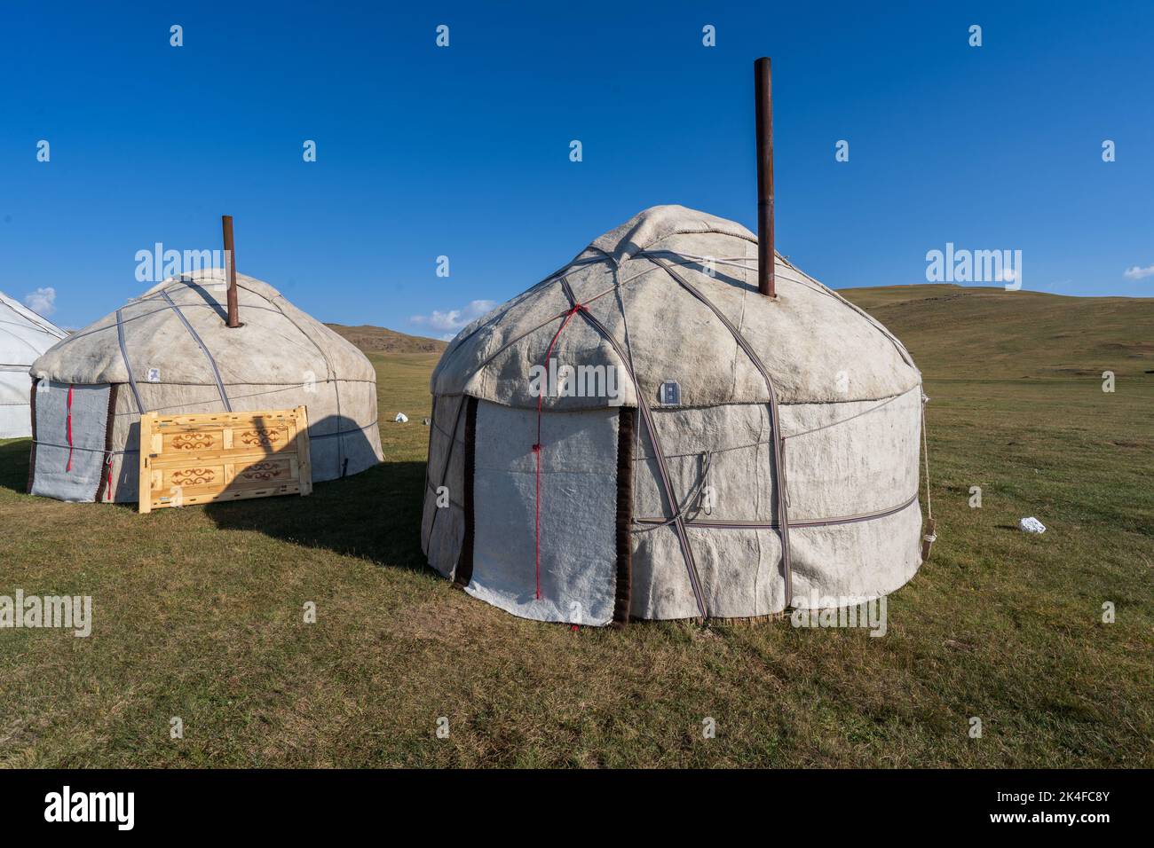 Campo turistico panoramico di yurt nomade sulle pianure del lago di Song Kul, Kirghizistan Foto Stock