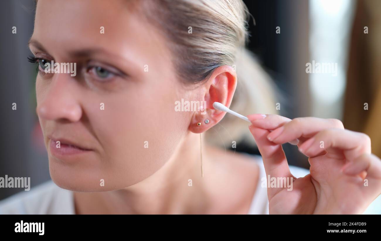 Donna pulisce le orecchie con bastoncini di cotone closeup Foto Stock