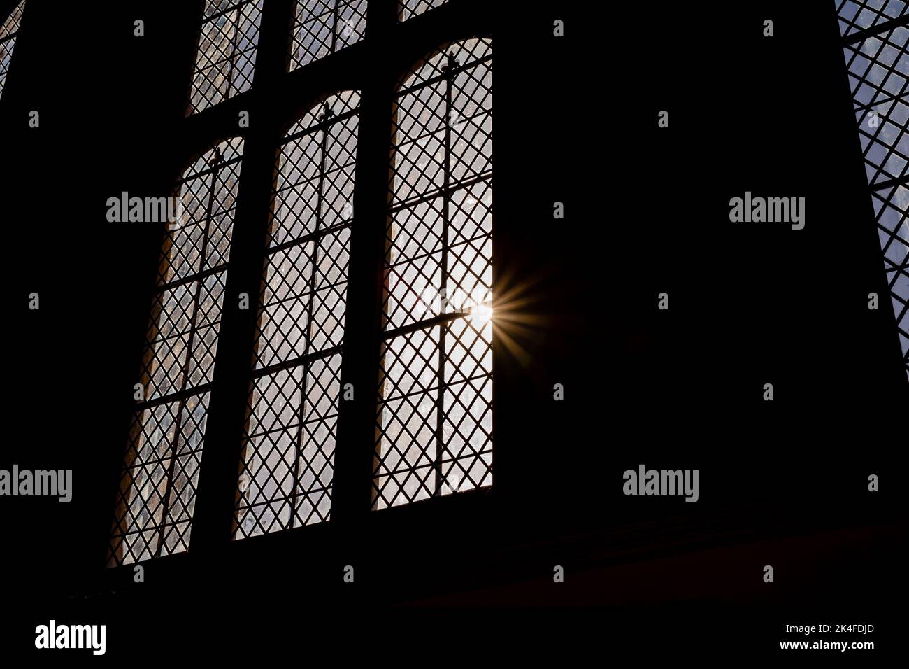 Luce del sole che passa attraverso una finestra di vetro macchiata Foto Stock