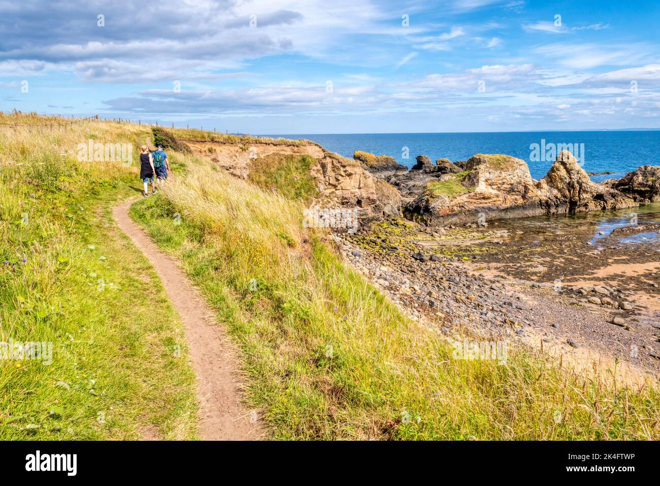 Persone che camminano lungo il sentiero costiero del Fife a St Monans, nella zona orientale di Fife, Scozia. Foto Stock