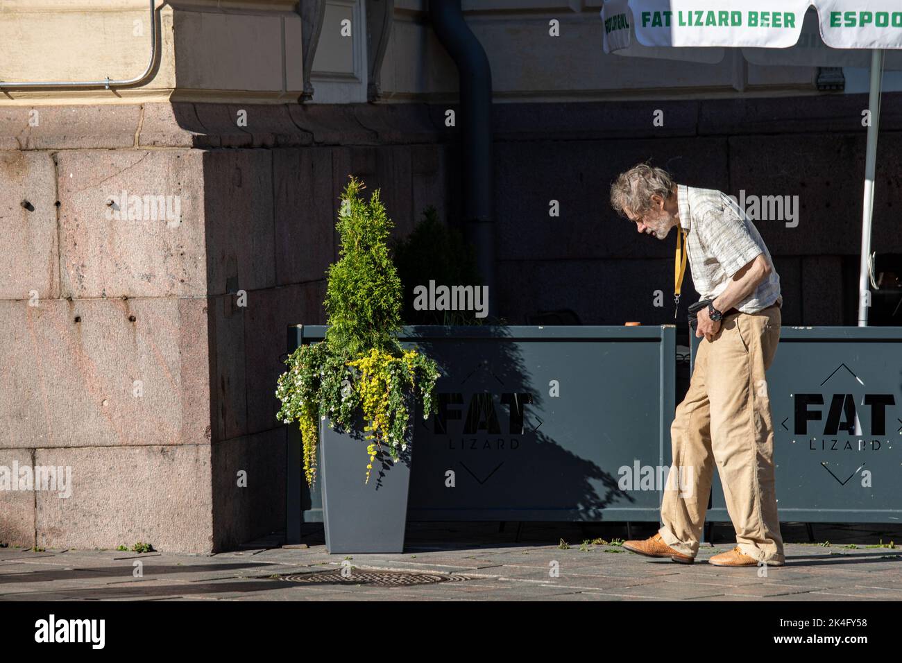 Uomo anziano che cammina sul marciapiede nel quartiere Kluivi di Helsinki, Finlandia Foto Stock