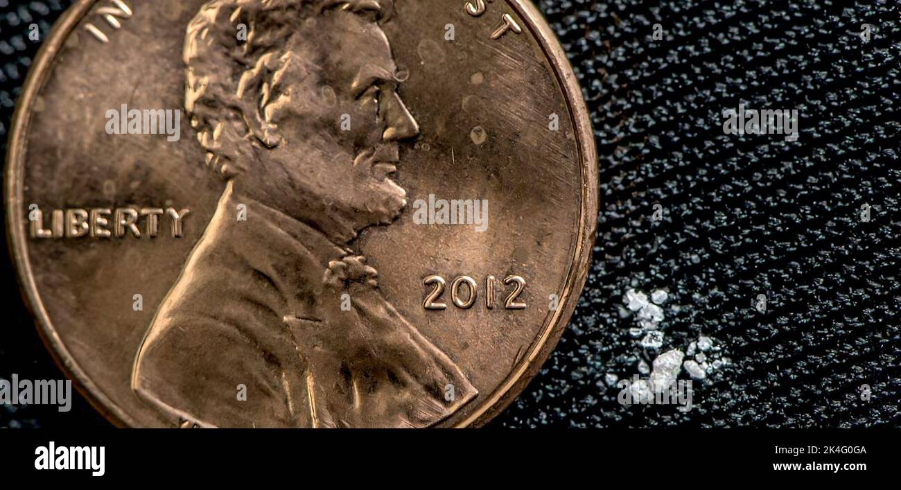 Fentynal - una quantità minuto - mostrata in relazione ad un penny - può essere una dose letale Foto Stock