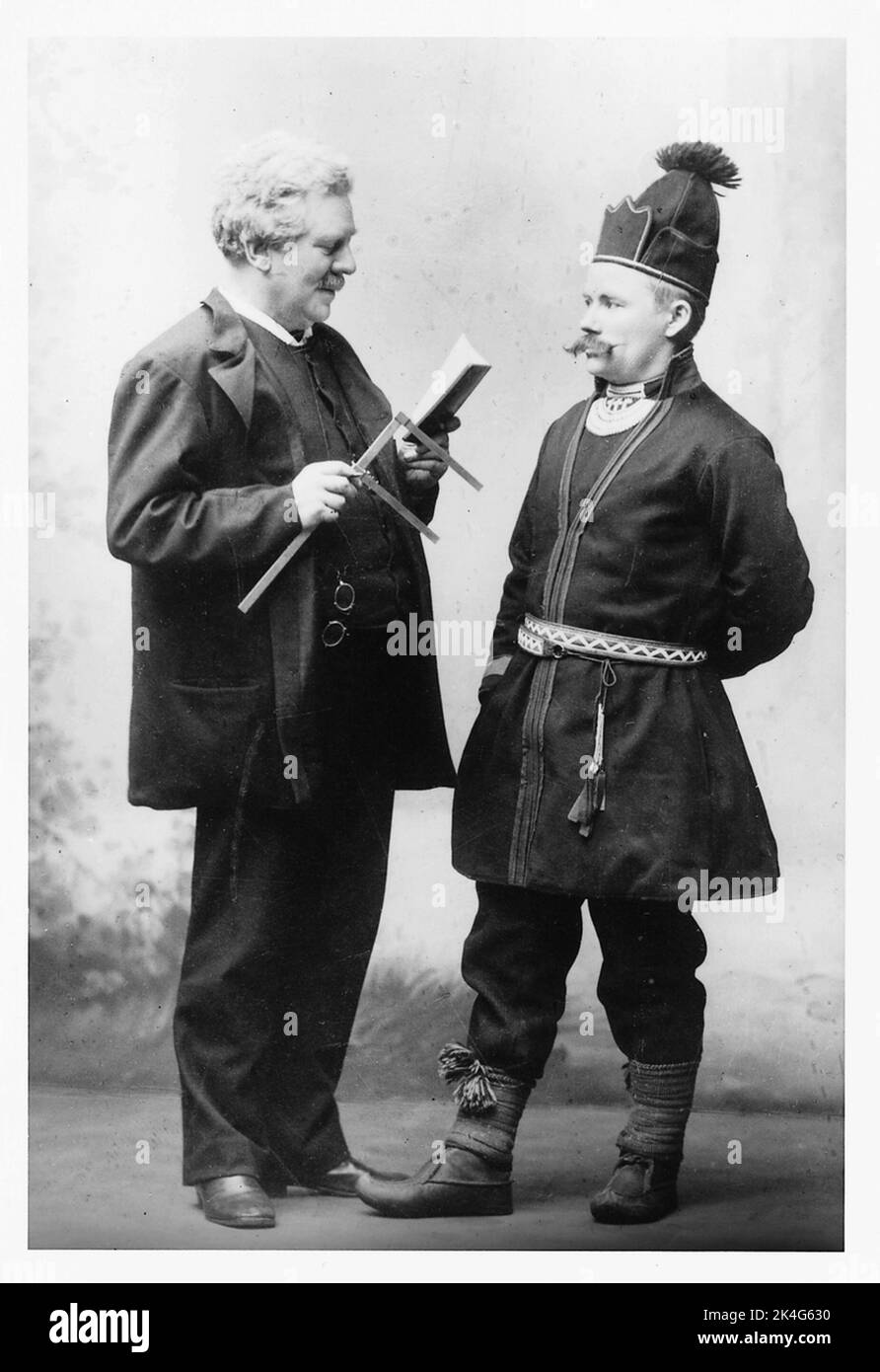 L'antropologo Gustaf Retzius nel processo di misurazione della testa di Härjedalsamen Fjellstedt, nel quadro della ricerca biologica razziale. Retzius a sinistra nella foto è vestito con un vestito e tiene una dimensione scorrevole in una mano mentre legge un libro. Davanti a lui, Fjellstedt si alza indossando il costume tradizionale Sami. Nordico Foto Stock