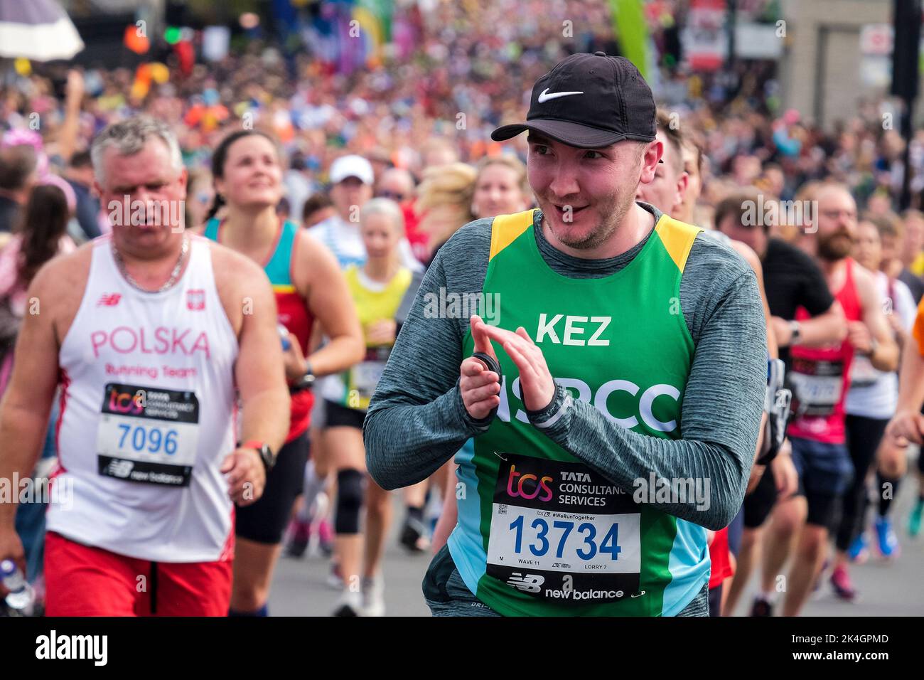 Londra UK, 2nd ottobre 2022. Più di 40.000 partecipanti scendono per le strade della capitale per la Maratona di Londra del 42nd. L'evento, che attrae i corridori d'élite e gli atleti in sedia a rotelle, solleva milioni di sterline per beneficenza grazie alla partecipazione dei corridori di club e fitness insieme a quelli che vogliono affrontare la sfida di 26 miglia. Un corridore applaude verso la folla in strada sulla rotta della Maratona di Londra. Foto Stock