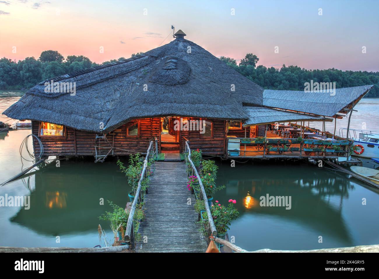 Splendido tramonto estivo con il tradizionale ristorante galleggiante rustico sulle stalle Stara Koliba, sul fiume Danubio a Belgrado, in Serbia. Foto Stock