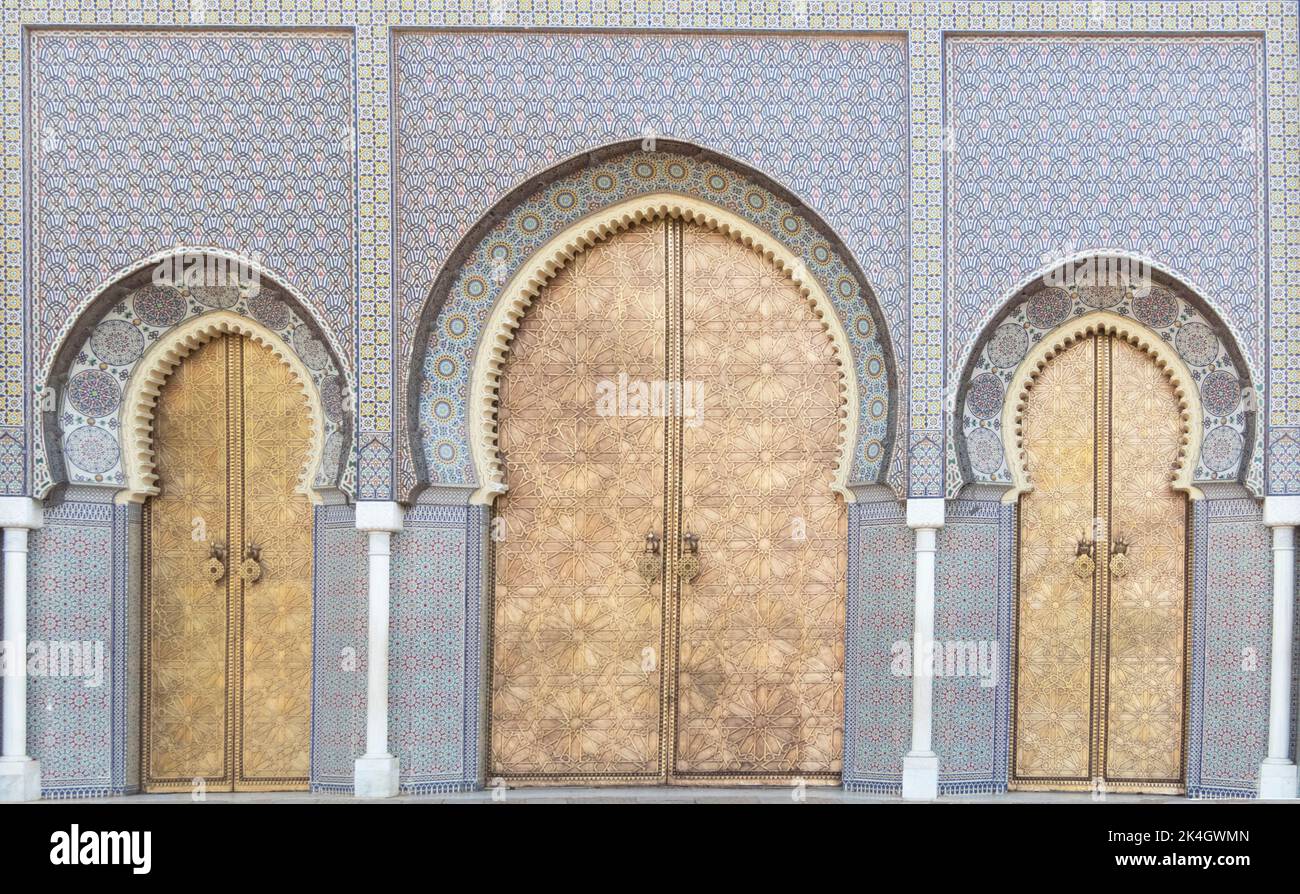 Porta dall'aspetto arabo con piastrelle ad arco blu con tre porte dorate Foto Stock