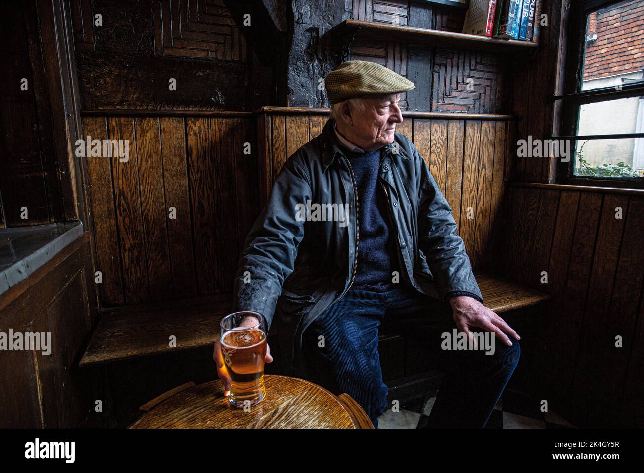 Uomo che ha una pinta al pub tradizionale di Haunch of Venison pubblica casa, salisbury, wiltshire, Inghilterra, Regno Unito Foto Stock