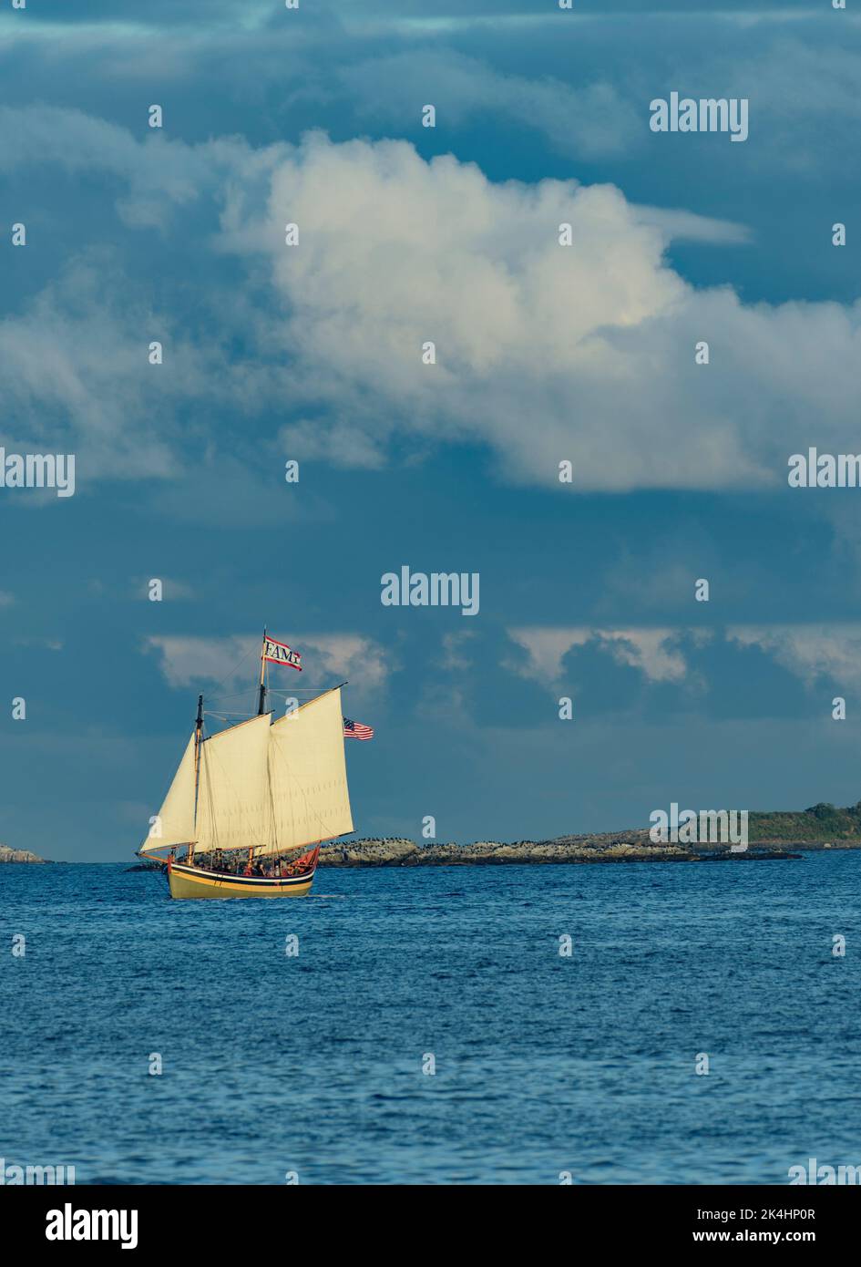 Schooner vela nell'Oceano Atlantico in un giorno di sole luminoso con cielo blu profondo e nuvole Puffy bianche Foto Stock