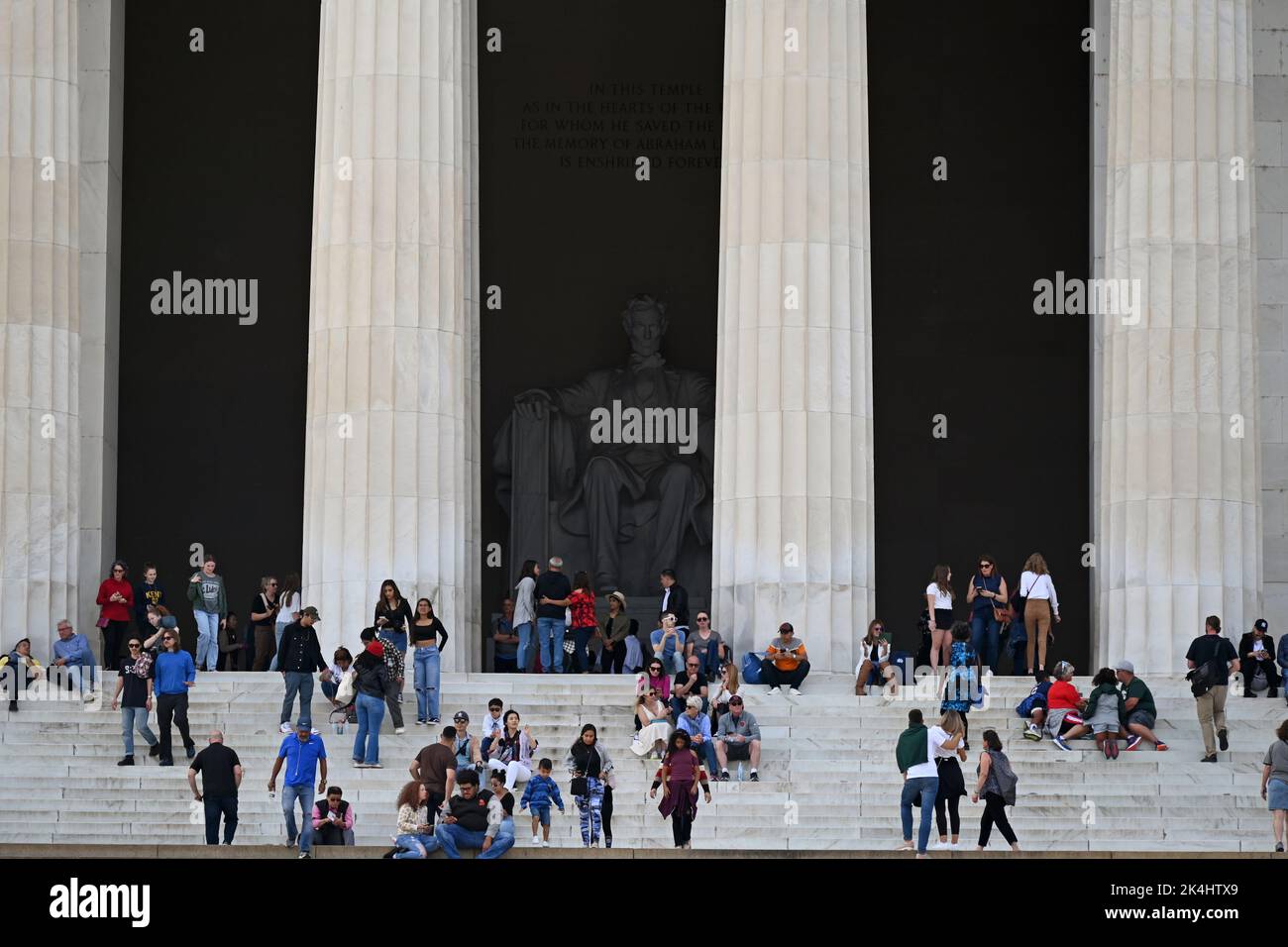 La figura di Abraham Lincoln si nasconde all'ombra dietro i visitatori sui gradini che portano al Lincoln Memorial a Washington, DC. Foto Stock