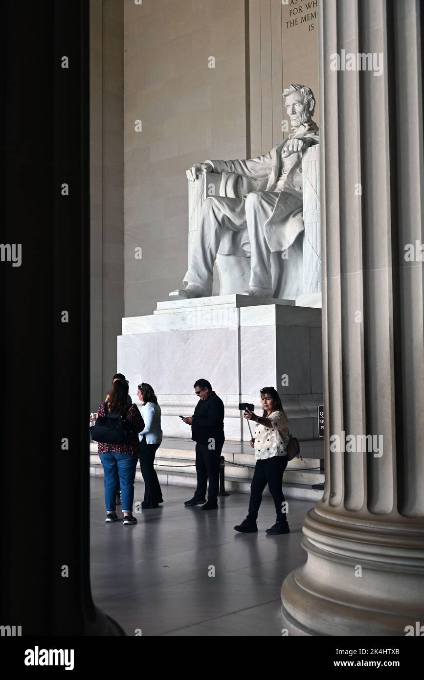 I turisti si trovano di fronte alla statua di Abraham Lincoln nella sala principale del Lincoln Memorial a Washington, DC. Foto Stock