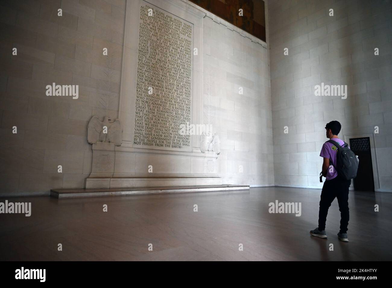 Un giovane legge il discorso di Gettysburg di Abraham Lincoln memorializzato sul muro al Lincoln Memorial a Washington, DC. Foto Stock