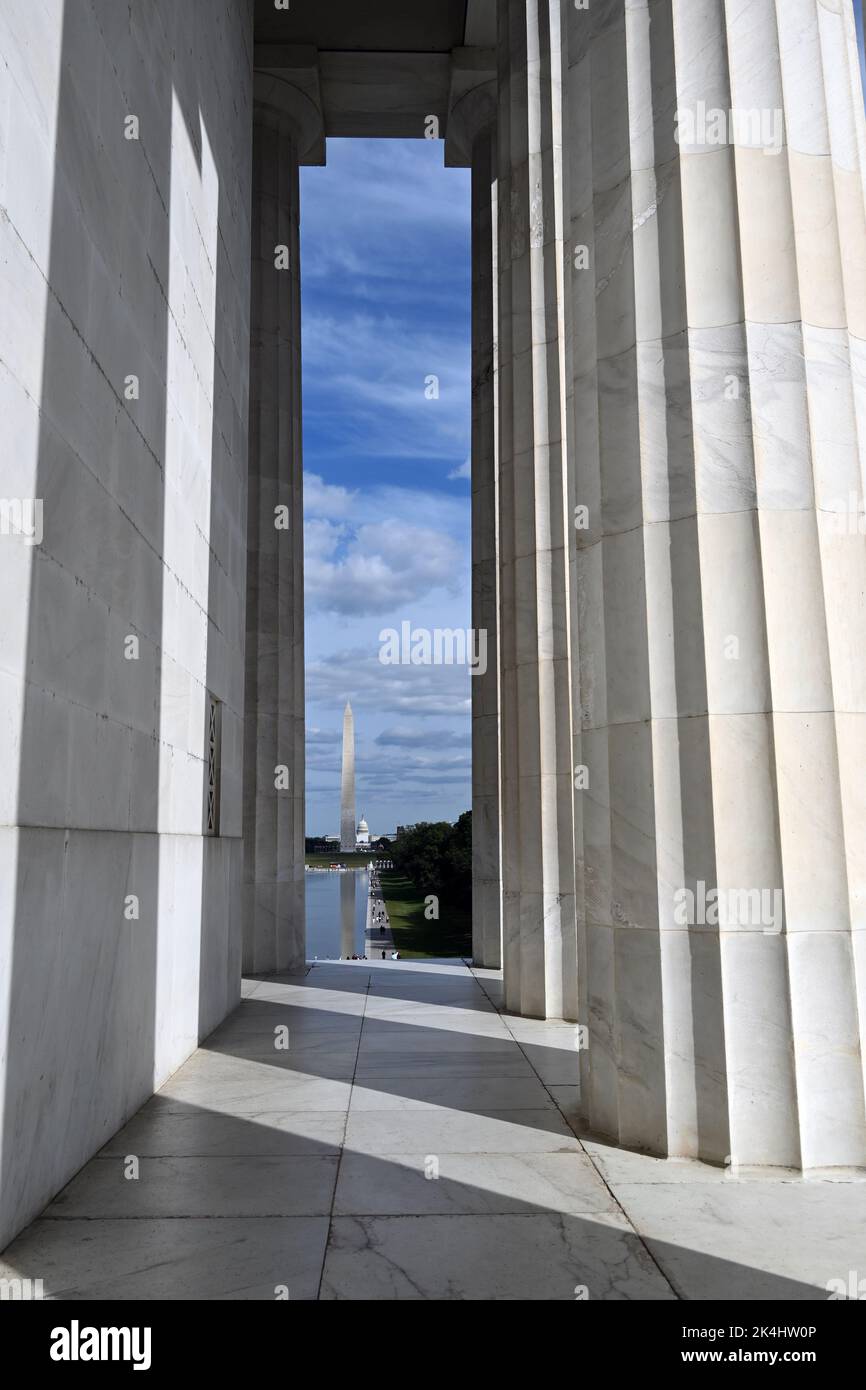 Il Washington Monument e il Reflecting Pond sono visibili guardando attraverso le colonne del Lincoln Memorial a Washington, DC. Foto Stock