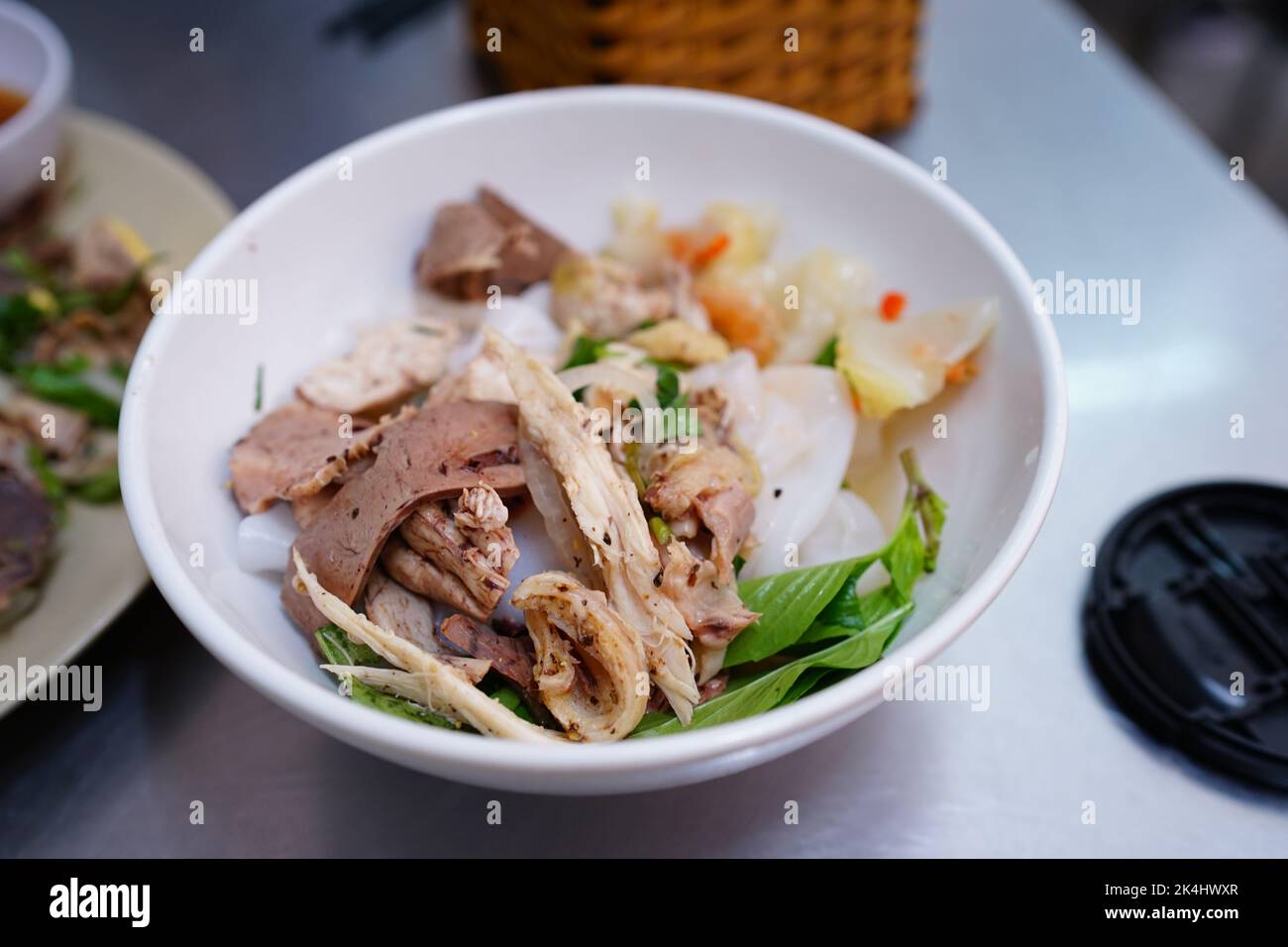 Bagnare la torta di riso con pollo e trippa (bánh ướt lòng gà) a da Lat, Vietnam Foto Stock