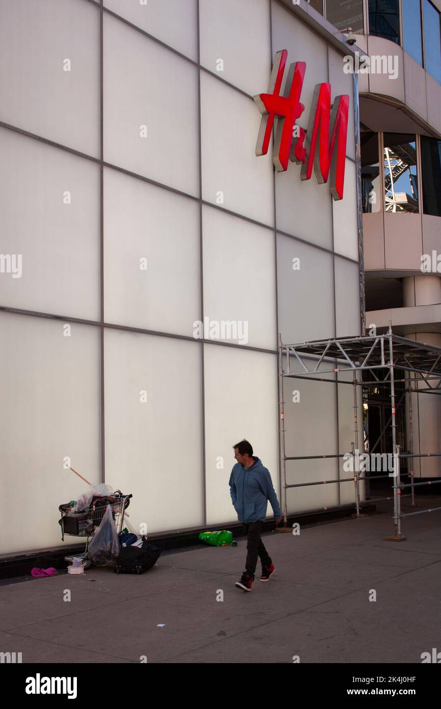 Uomo che passa gli effetti personali di un senza casa vicino al negozio H&M nel centro di Toronto, Canada Foto Stock