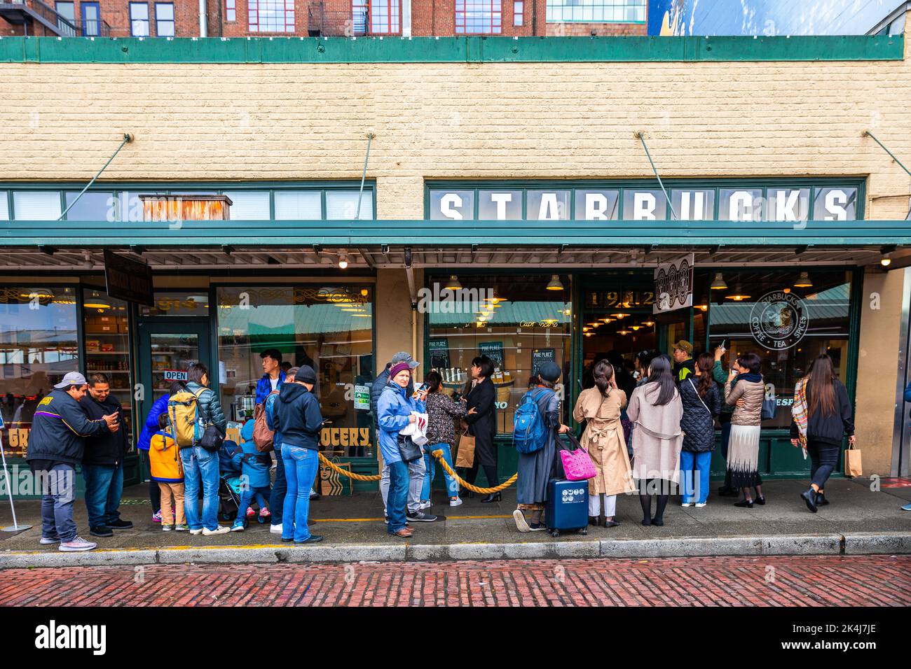 Seattle, Washington, USA - 9 ottobre 2019: Persone che aspettano sul sentiero in lunga coda per ordinare all'interno del primo Starbucks, il più classico e popolare Foto Stock