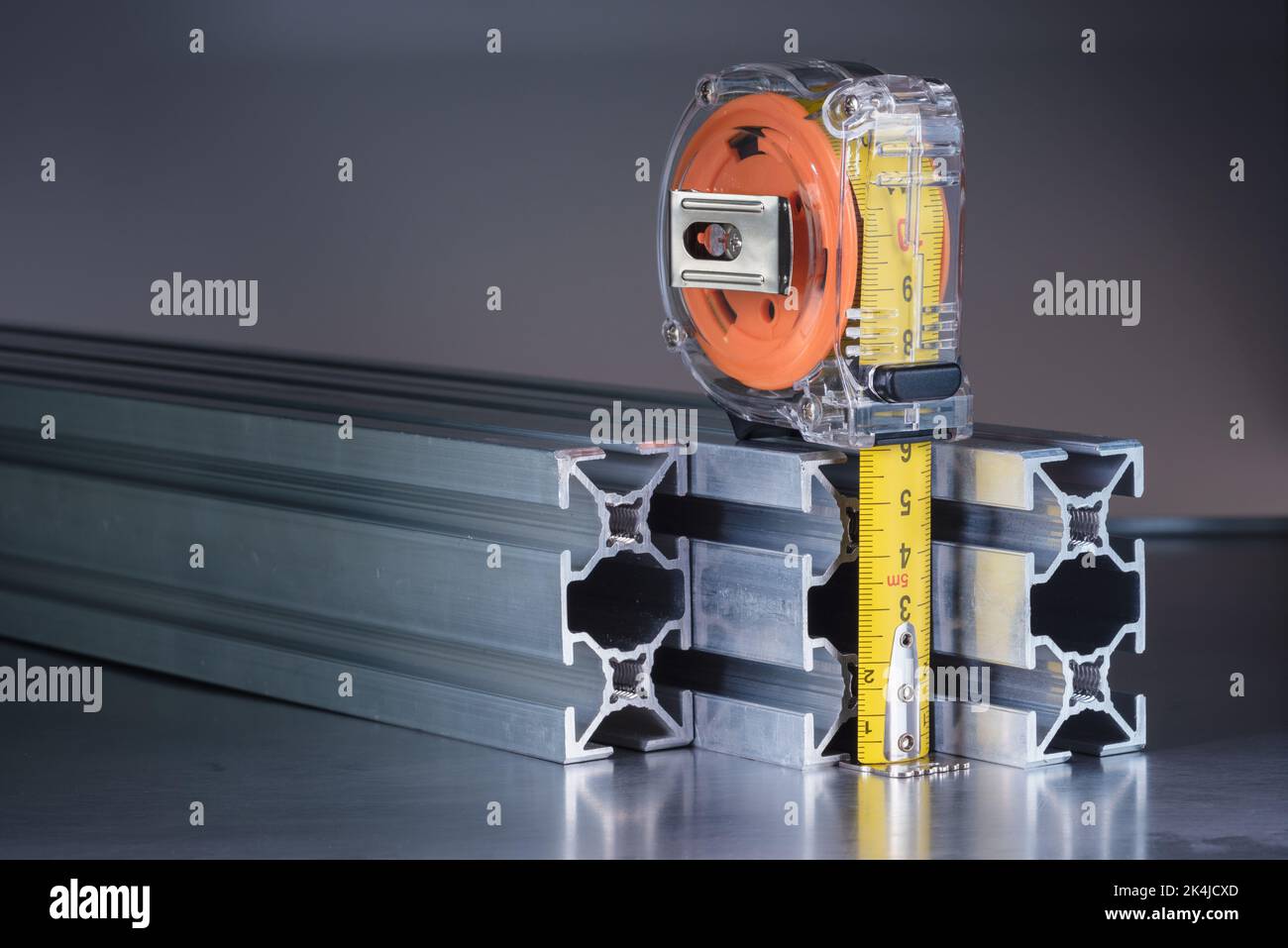 Metro a nastro con primo piano con profilo in metallo, utensile e componente dell'industria delle costruzioni Foto Stock