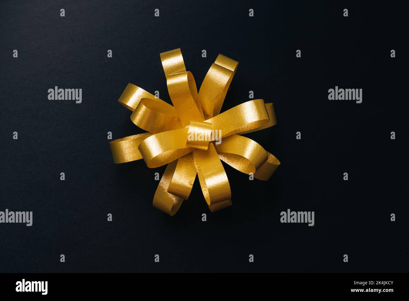 Arco d'oro per il presente su sfondo nero. Vista dall'alto. Black friday o Natale concetto Foto Stock