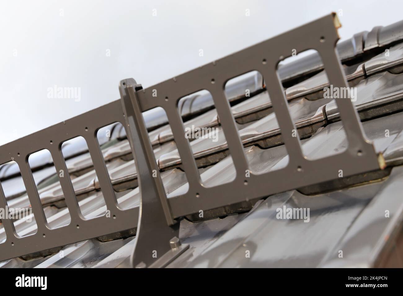 Primo piano di una protezione da neve su una nuova piastrella tetto Foto Stock