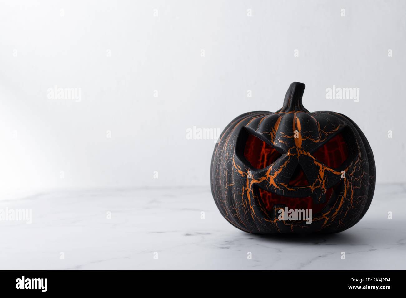 Zucca di Halloween nera su sfondo di marmo bianco Foto Stock